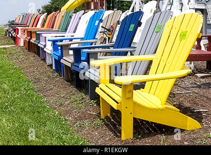 La gamme colorée de pelouse en bois chaises Adirondack sur route à vendre par propriétaire privé. Banque D'Images