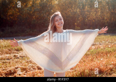 Cheerful girl avec les mains posées sur le terrain en automne chaud saison. Banque D'Images