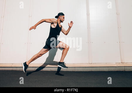 Jeune homme runner le long mur avec copie espace. Sport, Fitness, jogging Banque D'Images