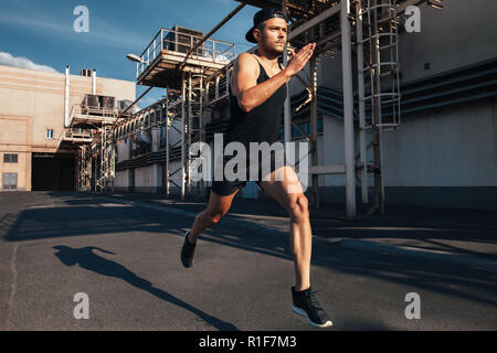 L'homme sportif courir vite dans la ville industrielle de fond. Le sport, l'athlétisme, fitness, jogging activité Banque D'Images