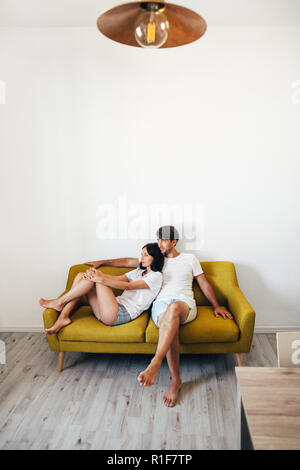 Jeune couple dans l'amour. Attractive man and woman relaxing together at home Banque D'Images