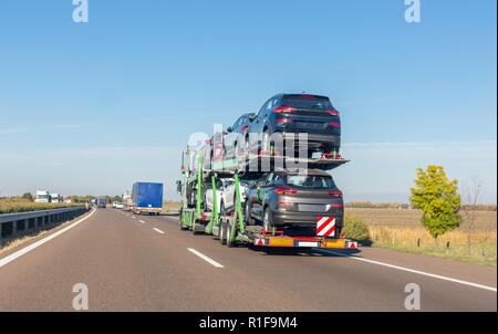 Remorque porte-voiture avec de nouvelles voitures en vente sur la plate-forme superposés sur l'autoroute Banque D'Images