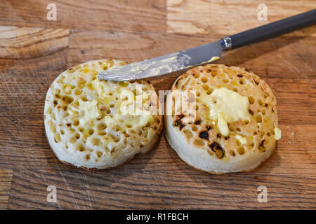 Les crumpets chauds grillés avec du beurre pour le petit déjeuner photographie prise par Simon Dack Banque D'Images