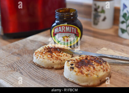 Les crumpets chauds grillés avec du beurre et de la marmite pour le petit déjeuner Banque D'Images