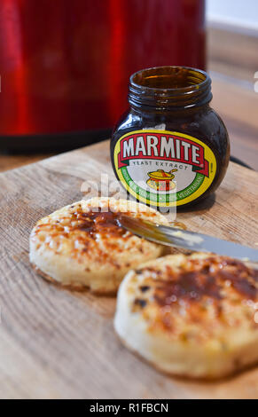 Les crumpets chauds grillés avec du beurre et de la marmite pour le petit déjeuner Banque D'Images