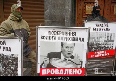 Des militants d'Ukrainien ultra C-14 Groupe d'extrême droite debout à côté d'affiches représentant les personnes qui, selon eux, les procureurs ont omis d'enquêter, au cours d'une manifestation près de l'office de procureur général à Kiev,. Les militants exigent la démission du procureur général Iury Loutsenko. Loutsenko le 6 novembre au Parlement ukrainien a annoncé sa décision de se retirer, et après cela, le législateur a tenu un vote sur la déclaration, où seulement 38 députés ont voté en faveur de la problématique. Banque D'Images