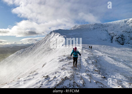 Une marchette descend le vent a diminué, en écailles d'eau devant elle, fouettées, Blencathra en hiver, Lake District, Cumbria, Royaume-Uni Banque D'Images