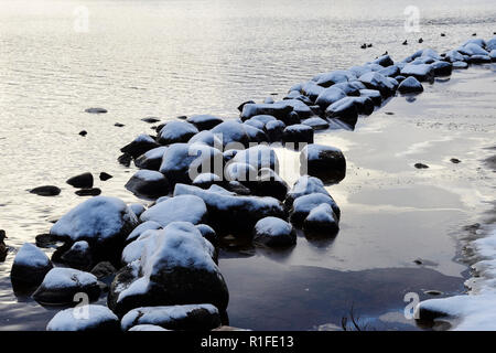 Rochers enneigés sur le Loch Morlich en neige de l'hiver, Glenmore Forest Park, près de Aviemore, région des hautes, Ecosse Banque D'Images