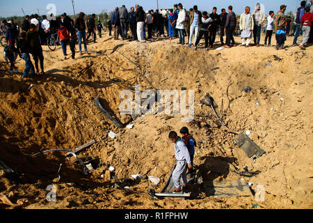 Les Palestiniens de l'Inspection du trou énorme résulte de bombardements israéliens à Khan Younis. De l'air israélienne a effectué la frappe aérienne dans le sud de la bande de Gaza de Khan Younis dans la nuit du 11 Nov causant des dommages à l'immeuble et les droits des victimes. Banque D'Images