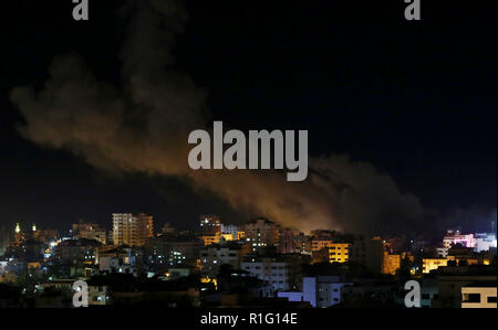 La ville de Gaza, bande de Gaza, territoire palestinien. 13Th Nov, 2018. La fumée s'élève monte à la suite de raids aériens israéliens visant la ville de Gaza le 13 novembre 2018. La puissance militaire d'Israël a dit qu'il transportait des frappes aériennes ''tout au long de la bande de Gaza'' après un barrage de roquettes palestiniennes de la bande de Gaza vers Israël. Le flare-up suit un conflit qui a éclaté au cours d'une opération des forces spéciales israéliennes dans la bande de Gaza la nuit précédente qui a tué huit personnes du mouvement Hamas Crédit : Ashraf Amra/APA/Images/fil ZUMA Alamy Live News Banque D'Images