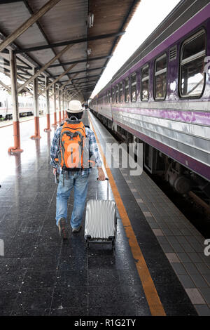 Voyageur asiatique homme avec effets personnels en attente de voyager par train à la gare de Chiang Mai, Thaïlande Banque D'Images