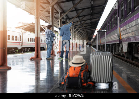 Voyageur asiatique homme avec effets personnels en attente de voyager par train à la gare de Chiang Mai, Thaïlande Banque D'Images