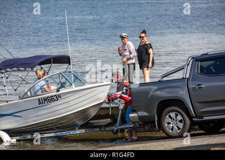 Le lancement de la famille leur bateau à moteur pour une journée de pêche à Deerubbun rampe de bateau à côté du pont transbordeur tourbes dans Mooney Mooney, New South Wales, Australie Banque D'Images