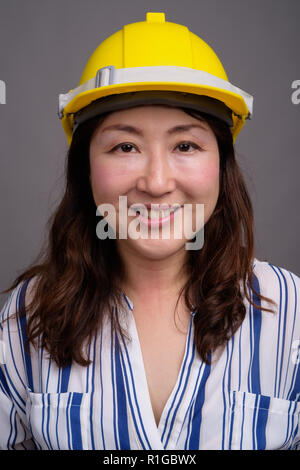 Mature Asian young construction worker wearing hardhat Banque D'Images