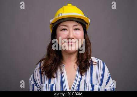 Mature Asian young construction worker wearing hardhat Banque D'Images