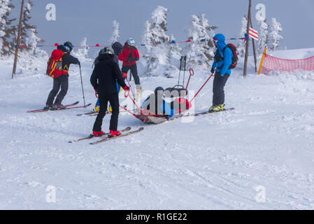 L'équipe de sauvetage ski avec brancard, apporte de l'aide pour faire du ski par mauvais temps. Banque D'Images