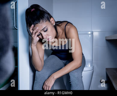 Belle femme latine assis dans la salle de bains qui souffrent d'Anorexie Boulimie se sentir triste et désespéré coupable dans les troubles de l'Alimentation et grossesse mauvais c Banque D'Images