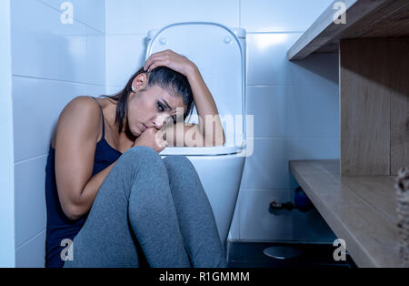 Belle femme latine assis dans la salle de bains qui souffrent d'Anorexie Boulimie se sentir triste et désespéré coupable dans les troubles de l'Alimentation et grossesse mauvais c Banque D'Images