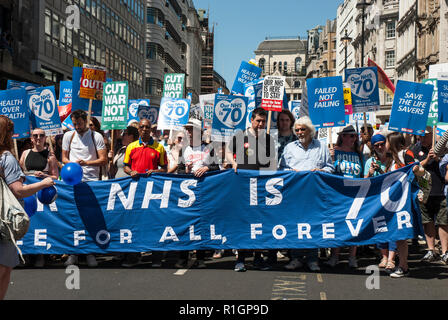 70e anniversaire Rassemblement pour célébrer la fondation de la NHS et protester contre les coupures avec de grandes bannières de premier plan et de nombreux placards, Banque D'Images