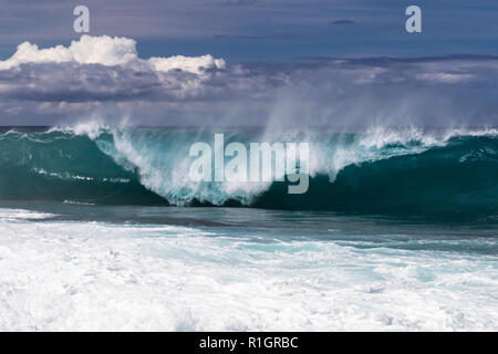 Vague curling sur plage hawaïenne, sur le point de s'écraser sur l'eau ci-dessous. Pulvériser sur l'onde arrière Ecornet souffler dessus. South Point. Embruns blanc jeté dans l'air. Banque D'Images