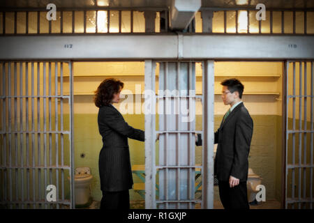 Businessman and businesswoman standing solennelle à l'intérieur d'une cellule de prison. Banque D'Images