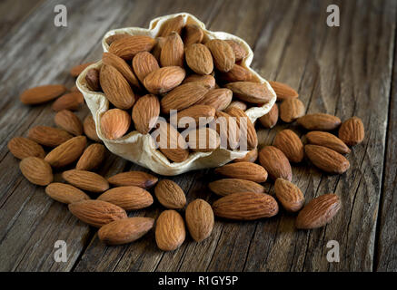 Bol d'amandes séchées rôti sur la vieille table en bois Banque D'Images