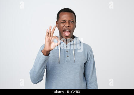 Excité réussie young African man isolés et montre ok sign Banque D'Images