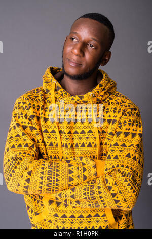 Beau jeune homme africain avec les cheveux courts contre gray backgrou Banque D'Images