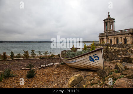 Le 19ème siècle en partie submergé l'église St Matthieu à Normanton dépasse sur Rutland Water, aux côtés d'un vieux bateau à rames. Banque D'Images