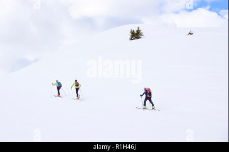 Dans la neige des montagnes dans les Alpes, trois randonneurs montée vers les sommets Banque D'Images