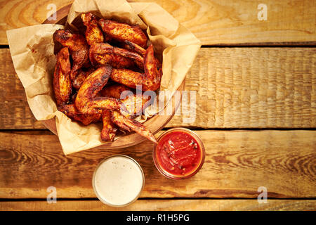 Vue du dessus des ailes de poulet frit délicieux avec des sauces sur une vieille table en bois Banque D'Images