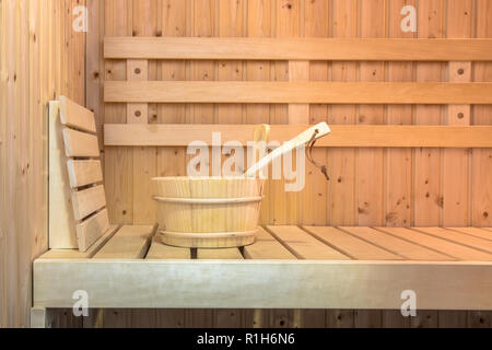 Siège à l'intérieur d'un sauna finlandais avec seau en bois Banque D'Images