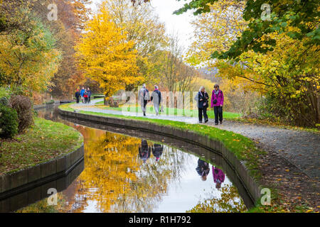 Les personnes appréciant l'air frais le long de la branche de l'Llangollen Shropshire Union Canal aux couleurs de l'automne dans les arbres le long du chemin de halage Banque D'Images