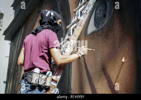 Artiste de rue Jorit travaille sur une fresque murale représentant Ilaria Cucchi dans le district d'Arenella. Des dizaines de passants lui photographie et l'amener de la nourriture et des boissons comprend : Jorit, Ilaria Cucchi Où : Naples, Italie Quand : 12 Oct 2018 Credit : IPA/WENN.com **Uniquement disponible pour publication au Royaume-Uni, USA, Allemagne, Autriche, Suisse** Banque D'Images