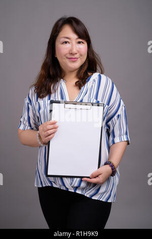 Japanese businesswoman holding clipboard avec papier blanc vide Banque D'Images