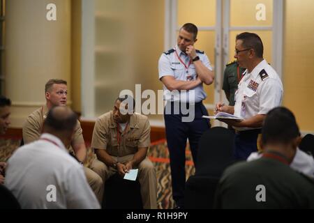 Le lieutenant de la Marine américaine Daniel Alden et Virginia Army National Guard, Lt Col Nathan Tyau de discuter des avantages et inconvénients de l'utilisation des ressources navales pour faciliter une prestation vitale dans la bhakti Gema scénario, le 19 septembre 2018, à Jakarta en Indonésie. Gema bhakti est une force conjointe personnel multinational exercice où le personnel militaire des États-Unis et de la commande de l'Indo-Pacifique Indonésie travailler à travers un processus connu sous le nom de processus de prise de décisions militaires. Ce processus est une étape cruciale qui implique le personnel du commandant de travailler avec tous les niveaux de commandes pour définir la mission, ses variables, et la situation europ Banque D'Images