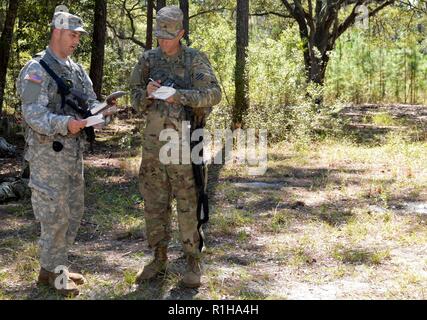 La Garde nationale de l'Armée de Géorgie Le Sgt. John D. Bennett, un fantassin attribué à l'entreprise Delta à base de Valdosta, 2e Bataillon, 121e Régiment d'infanterie et le Sgt. Jason Zimmerman, un assistant avec le sergent des opérations Fort Stewart, 3e Division d'infanterie, poste de commandement principal détachement opérationnel, réviser notes en préparation pour réagir à un contact ennemi percer à Fort Stewart, en Géorgie le 19 septembre 2018. Dix-sept soldats ont assisté à des sous-officiers d'une semaine d'Initiation à l'agent qui se concentre sur les responsabilités de sous-officier subalterne dans un champ de l'environnement. Banque D'Images