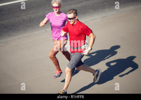 Photos de sportifs et de sportives s'exécutant sur route asphaltée sur journée d'été Banque D'Images