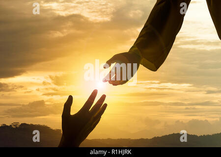 Silhouette de Jésus donner coup de main avec fond coucher de soleil Banque D'Images