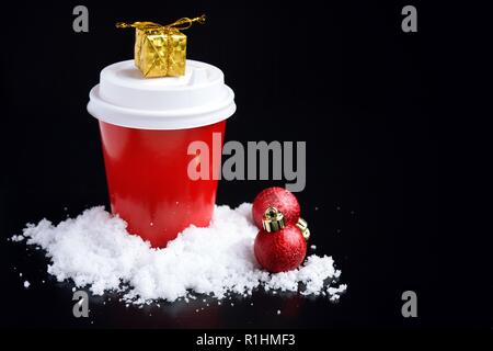 Café pour aller en rouge tasse et décorations de Noël sur noir Banque D'Images