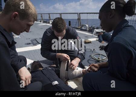Mer Méditerranée (sept. 20, 2018) marins fournissent de l'aide à un dommage Controlman Fireman Maurice Cossy pendant une urgence médicale à bord du forage de la classe Arleigh Burke destroyer lance-missiles USS Carney (DDG 64) Le 20 septembre 2018. Carney, l'avant-déployé à Rota, en Espagne, est sur sa cinquième patrouille dans la sixième flotte américaine zone d'opérations à l'appui d'alliés et de partenaires régionaux ainsi que les intérêts de sécurité nationale des États-Unis en Europe et en Afrique. Banque D'Images