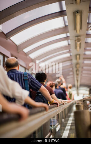 Groupe de personnes se déplaçant vers le haut sur un escalator. Banque D'Images
