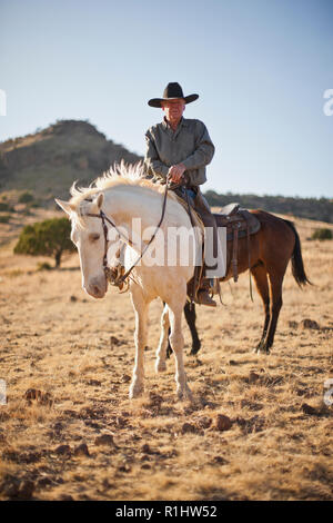 Portrait d'un éleveur assis sur un cheval. Banque D'Images