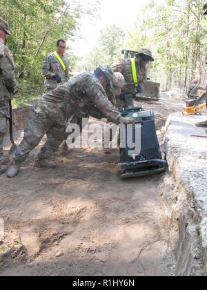 La CPS. Darius Davis, 161e, 27e Compagnie d'appui du bataillon du génie (Combat) (Airborne), pousse une main toucher à l'aide d'autres soldats en réparant une route militaire délavé à Ocean Terminal Sunny Point, N.C., 22 septembre. L'unité, ainsi que pour le personnel de cinq districts de l'Army Corps of Engineers des États-Unis, est l'aide à l'installation des secours déployés à la suite de l'ouragan Florence. Banque D'Images