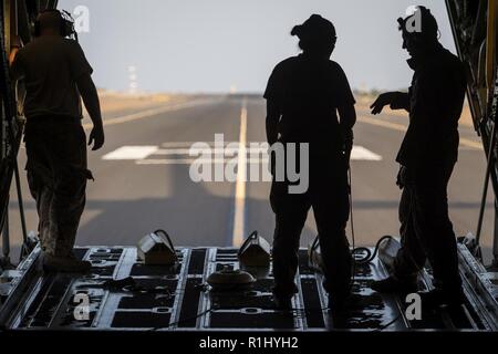 Aviateurs affectés à la 75e Escadron de transport aérien expéditionnaire stand by sur la rampe avec des cales d'avions comme l'avion-taxis à leur retour d'une mission au Camp Lemonnier, Djibouti, 22 Septembre, 2018. Le 75e prend en charge EAS Combined Joint Task Force - Corne de l'Afrique avec les évacuations sanitaires, les secours en cas de catastrophe humanitaire, et les opérations de largage. Banque D'Images