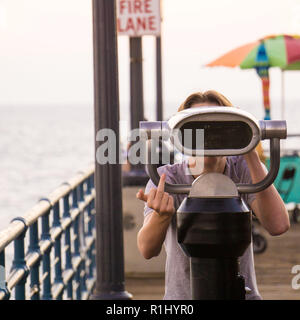 Un petit garçon avec télescope sur Santa Monica Pier Banque D'Images