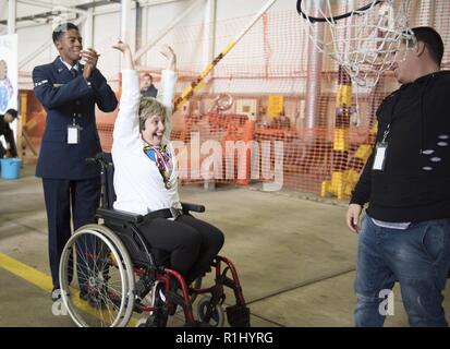 Un athlète célèbre avec son escorte, d'un membre de la 1re classe Clarence Bennett, après l'obtention d'un terrain de basket-ball dans le cerceau à la 37e Journée des sports spécial Joan Mann à RAF Mildenhall, Angleterre, du 22 septembre 2018. Des sportifs de 28 écoles locales et d'organisations ont concouru dans 12 disciplines sportives, y compris le basket-ball en fauteuil roulant, slalom, et le football américain. Banque D'Images