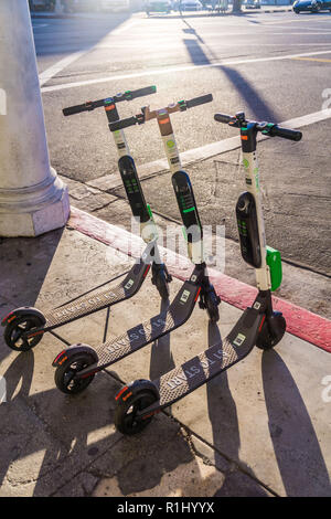 Un groupe de la chaux des scooters électriques en attente pour les cavaliers à Venice Beach Banque D'Images