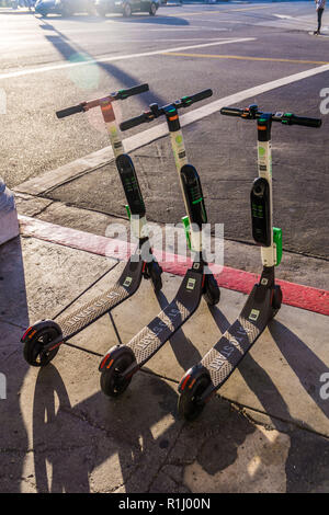 Un groupe de la chaux des scooters électriques en attente pour les cavaliers à Venice Beach Banque D'Images