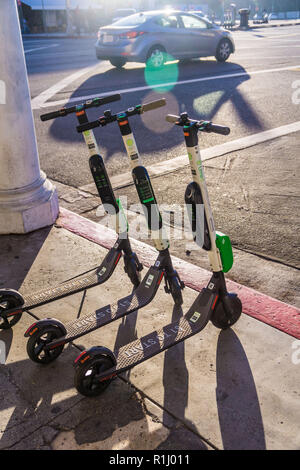 Un groupe de la chaux des scooters électriques en attente pour les cavaliers à Venice Beach Banque D'Images